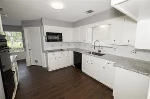 a kitchen with cabinets stainless steel appliances a sink and a window