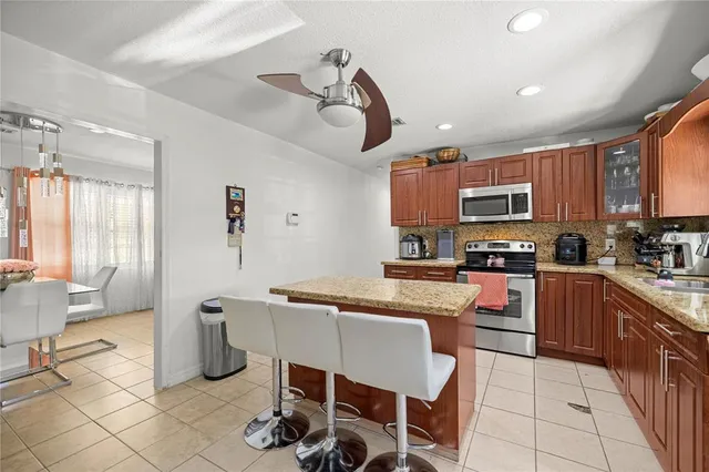 a kitchen with stainless steel appliances a stove a sink a dining table and chairs