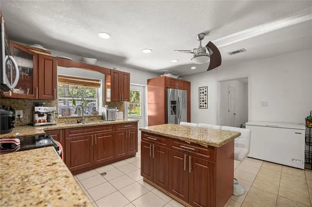 a kitchen with stainless steel appliances granite countertop a sink stove and refrigerator