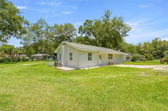 a view of a house with backyard and trees