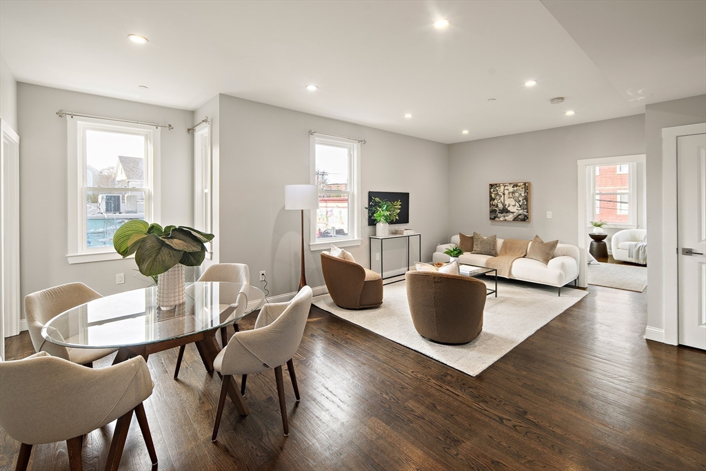 9-11 Boynton Street, Unit 2 Boston, MA 02130 - Photo 20 of 30 a living room with couches and a dining table with wooden floor