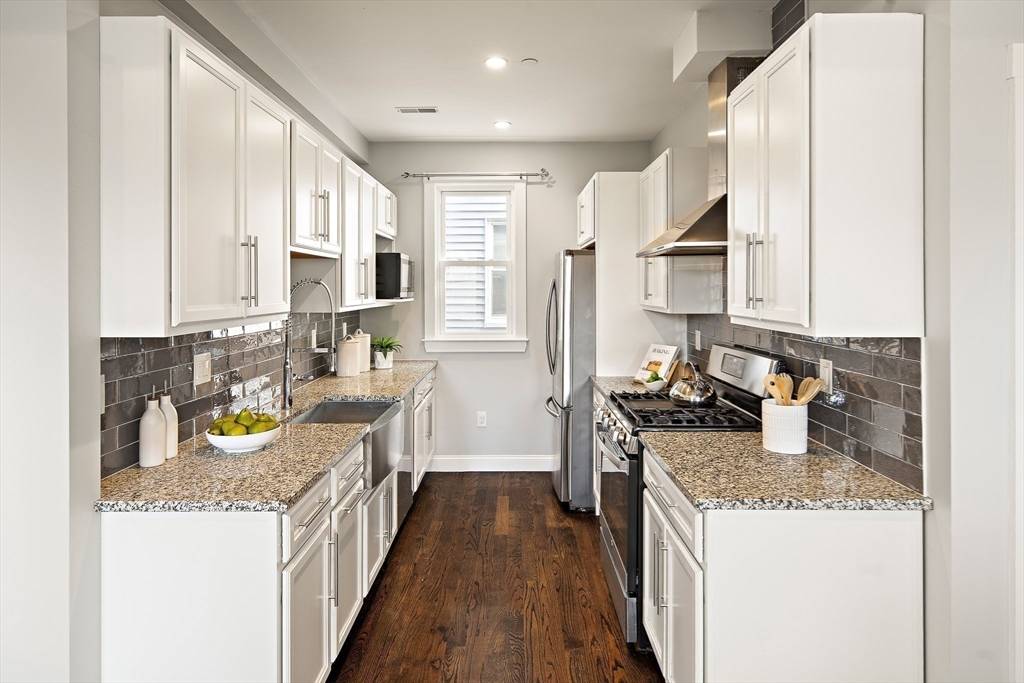 9-11 Boynton Street, Unit 2 Boston, MA 02130 - Photo 4 of 30 a kitchen with a stove top oven sink and cabinets