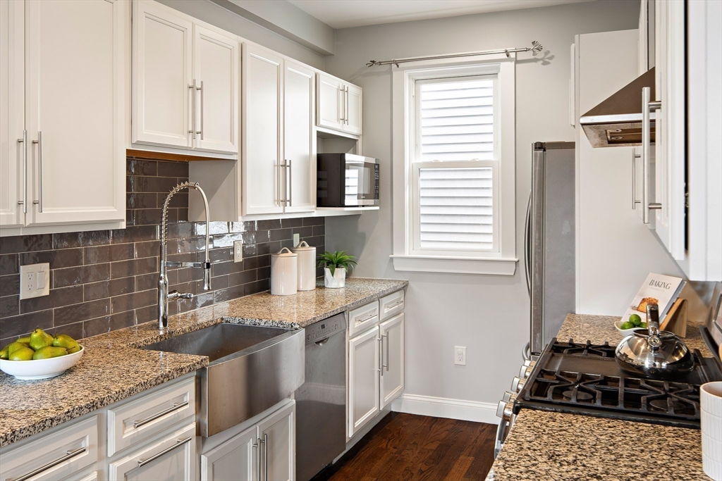 9-11 Boynton Street, Unit 2 Boston, MA 02130 - Photo 5 of 30 a kitchen with granite countertop kitchen island wooden cabinets and a sink