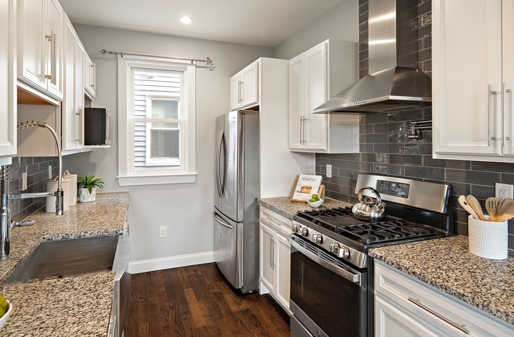9-11 Boynton Street, Unit 2 Boston, MA 02130 - Photo 6 of 30 a kitchen with granite countertop a stove sink and refrigerator