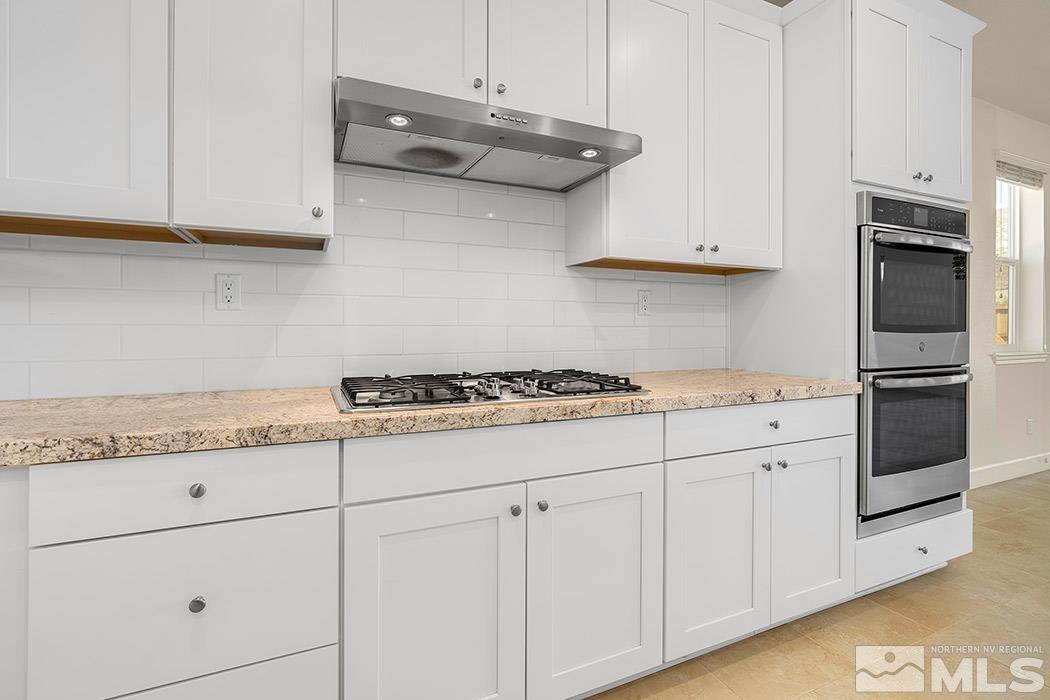 10410 Palladium Mine Drive Reno, NV 89521 - Photo 11 of 26 a kitchen with granite countertop white cabinets and stainless steel appliances