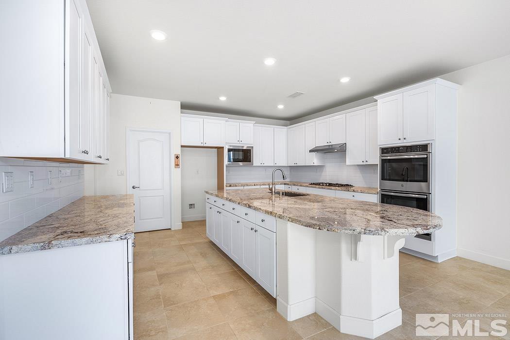 10410 Palladium Mine Drive Reno, NV 89521 - Photo 12 of 26 a kitchen with stainless steel appliances granite countertop a sink stove and refrigerator