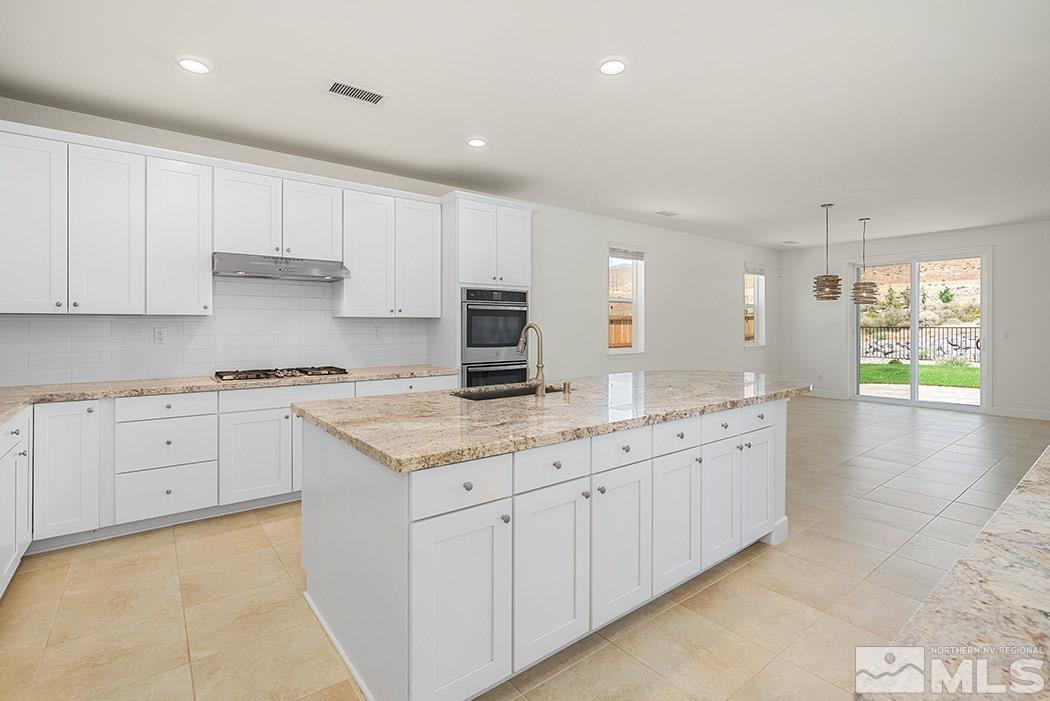 10410 Palladium Mine Drive Reno, NV 89521 - Photo 10 of 26 a kitchen with granite countertop white cabinets and white appliances