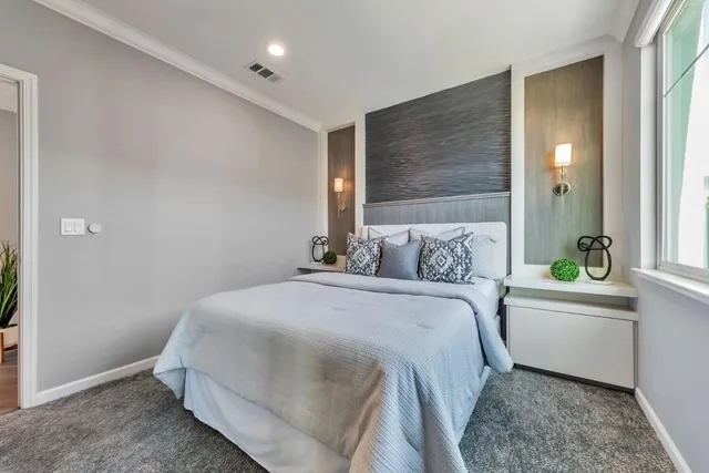 a bedroom with a bed and a large window