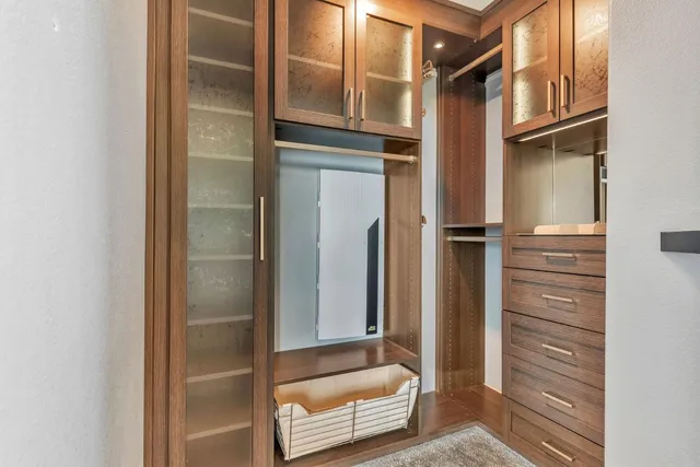 a bathroom with a granite countertop sink a toilet a mirror a vanity and shower