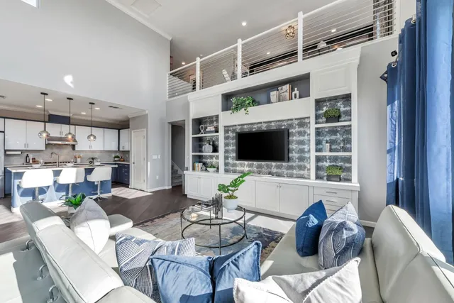 a living room with furniture a flat screen tv and kitchen view