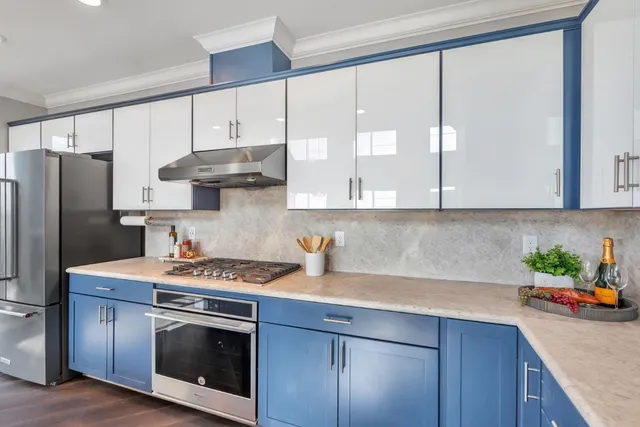 a kitchen with stainless steel appliances white cabinets and a stove top oven