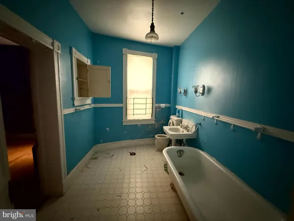 a bathroom with a tub sink and mirror