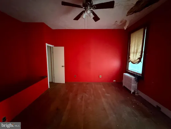 a view of empty room with wooden floor and windows