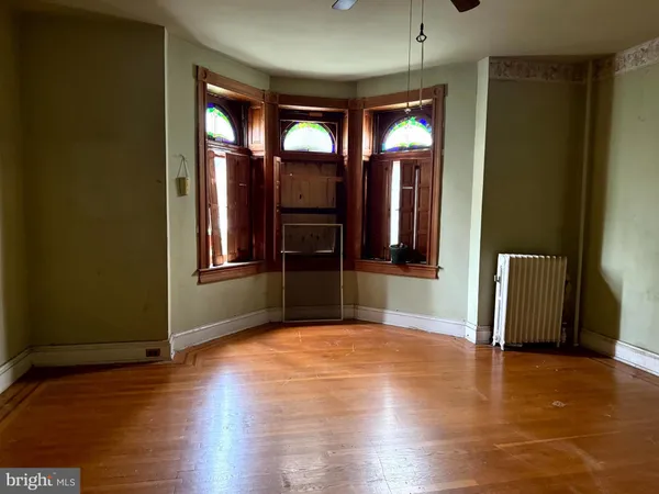 a view of a hallway with wooden floor and a living room