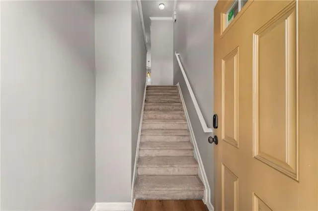 a view of staircase with wooden floor and white door
