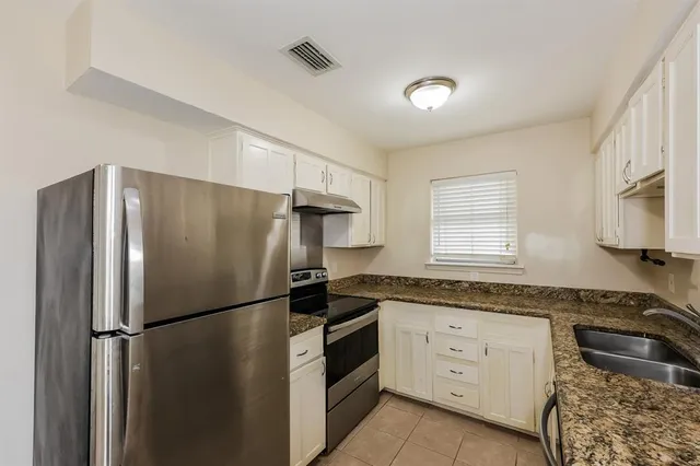 a kitchen with a refrigerator sink stove and cabinets