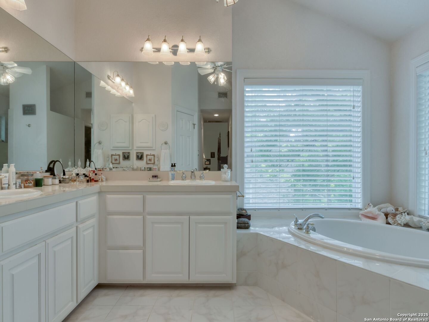 109 A Ammann Road Boerne, TX 78015 - Photo 33 of 67 a bathroom with a tub a double vanity sink a vanity a lamp and a mirror