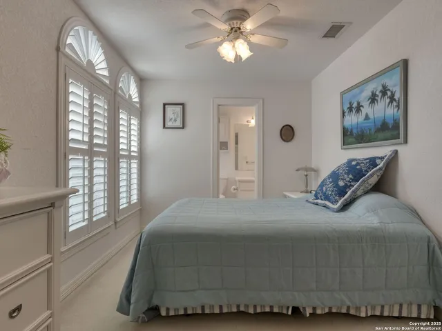 a bedroom with a bed and a flat tv screen on the dresser