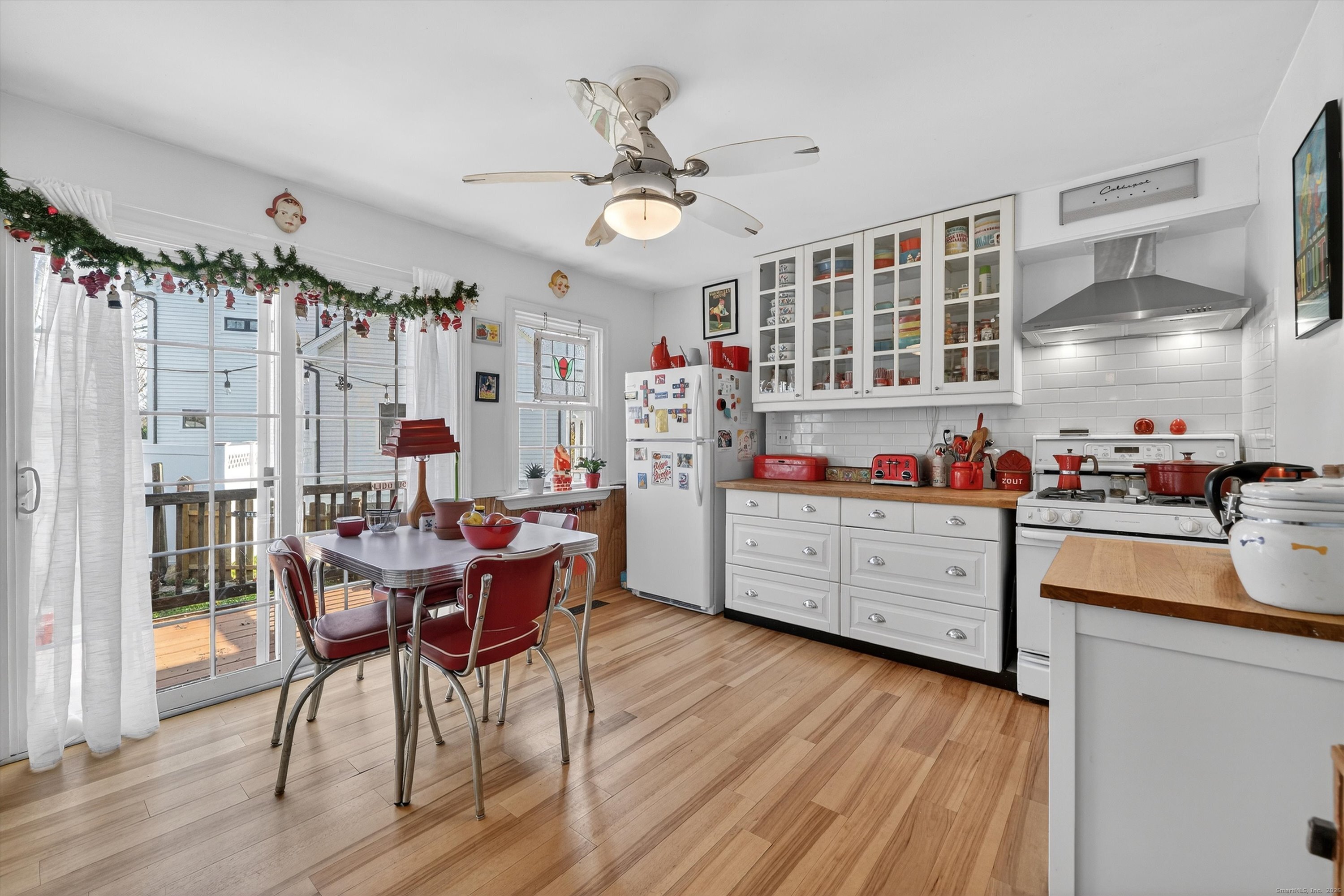 246 Romanock Road Fairfield, CT 06825 - Photo 8 of 37 a kitchen with stainless steel appliances kitchen island granite countertop a table chairs and a wooden floor