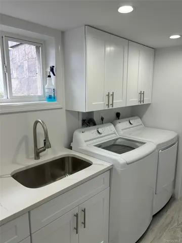 a view of a kitchen sink stove top oven and cabinets