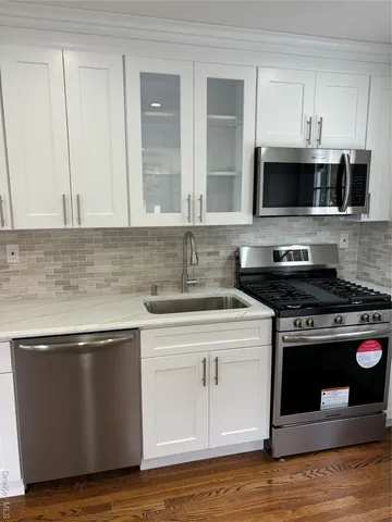 a kitchen with stainless steel appliances granite countertop a stove and a microwave