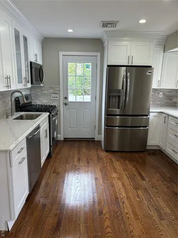a kitchen with a refrigerator sink and wooden floor