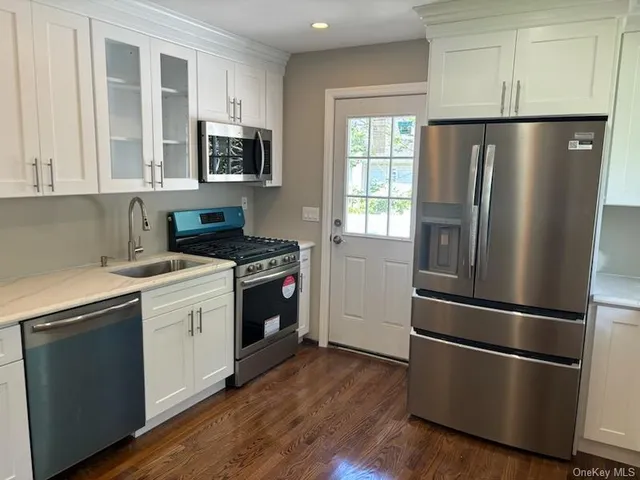 a kitchen with a refrigerator stove and wooden cabinets