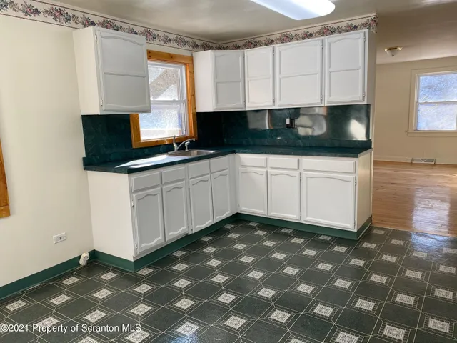 a kitchen with a sink a stove and cabinets