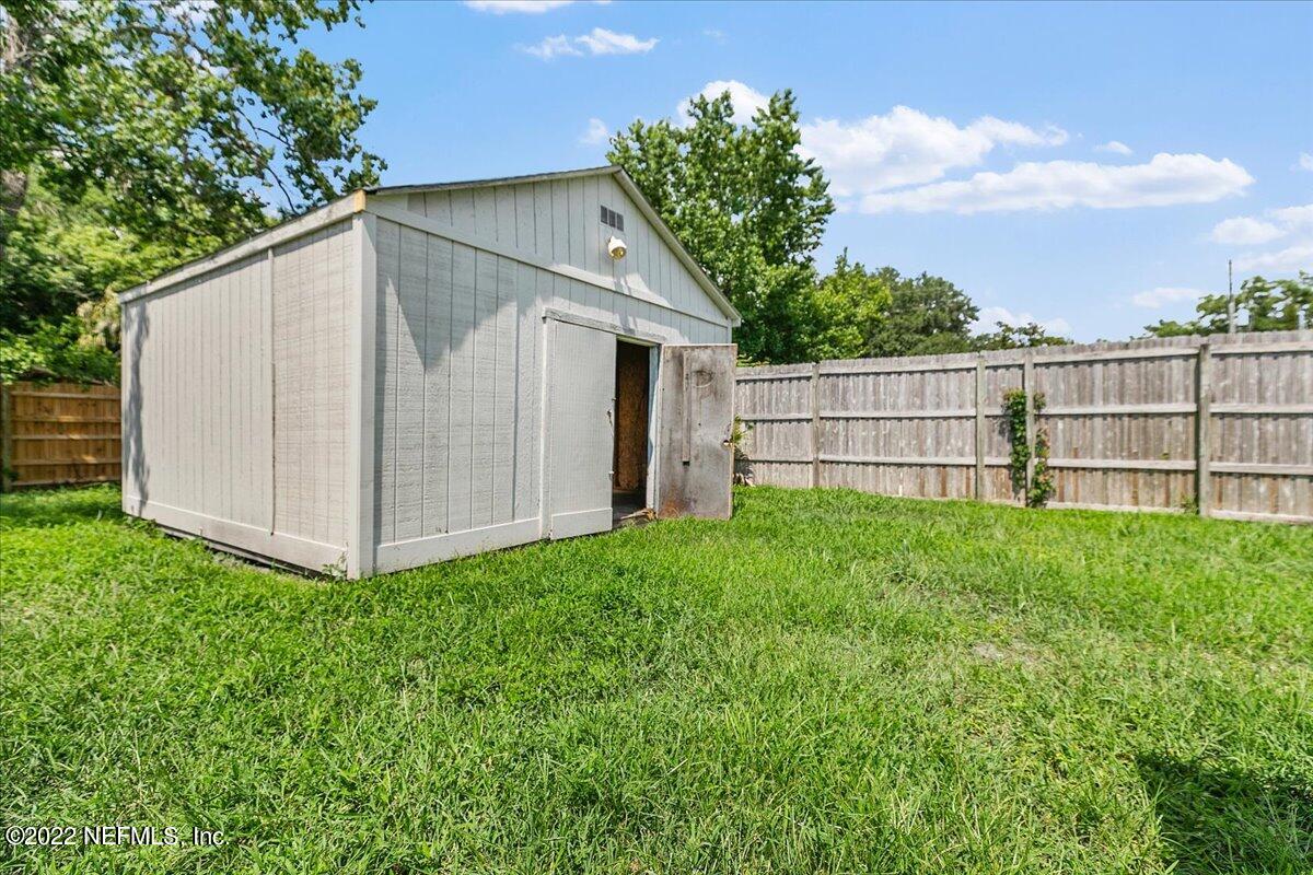 4057 Dayrl Road Jacksonville, FL 32207 - Photo 15 of 21 a view of a backyard with a large tree and wooden fence