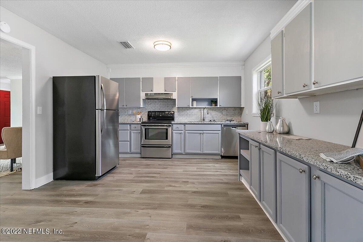 4057 Dayrl Road Jacksonville, FL 32207 - Photo 4 of 21 a kitchen with kitchen island a refrigerator sink and stove
