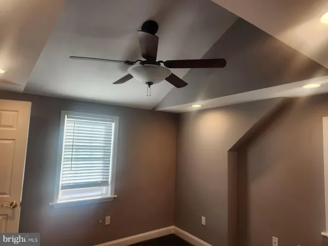 a view of a room with a ceiling fan and a window