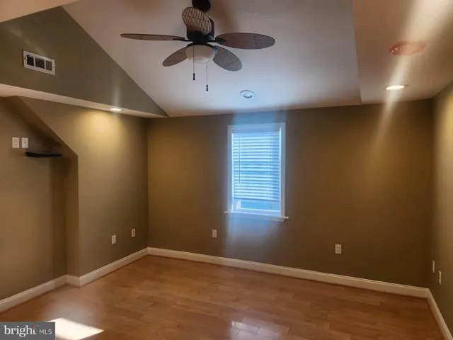 an empty room with a ceiling fan and window