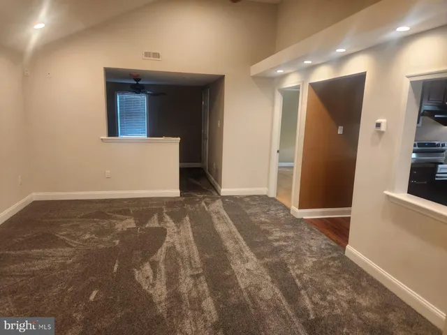 a view of a hallway with a refrigerator and a stove top oven