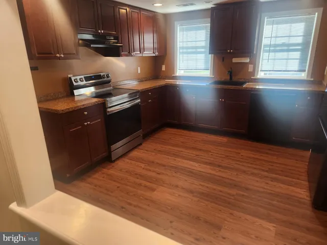 a kitchen with stainless steel appliances granite countertop a stove a sink and a microwave