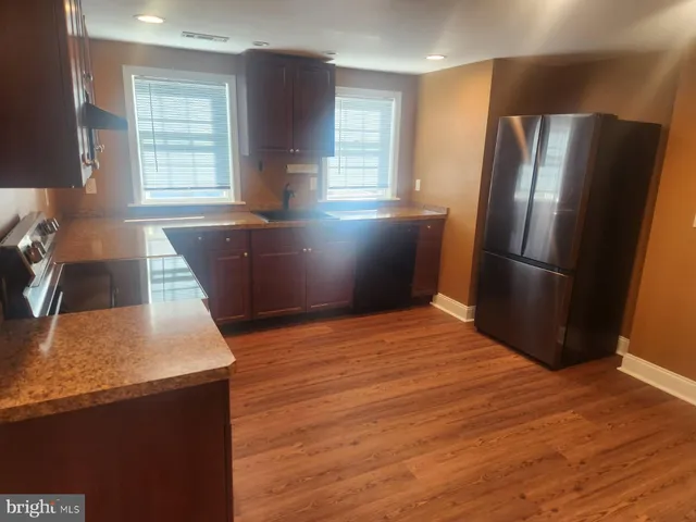 a kitchen with stainless steel appliances granite countertop a refrigerator a sink and a stove