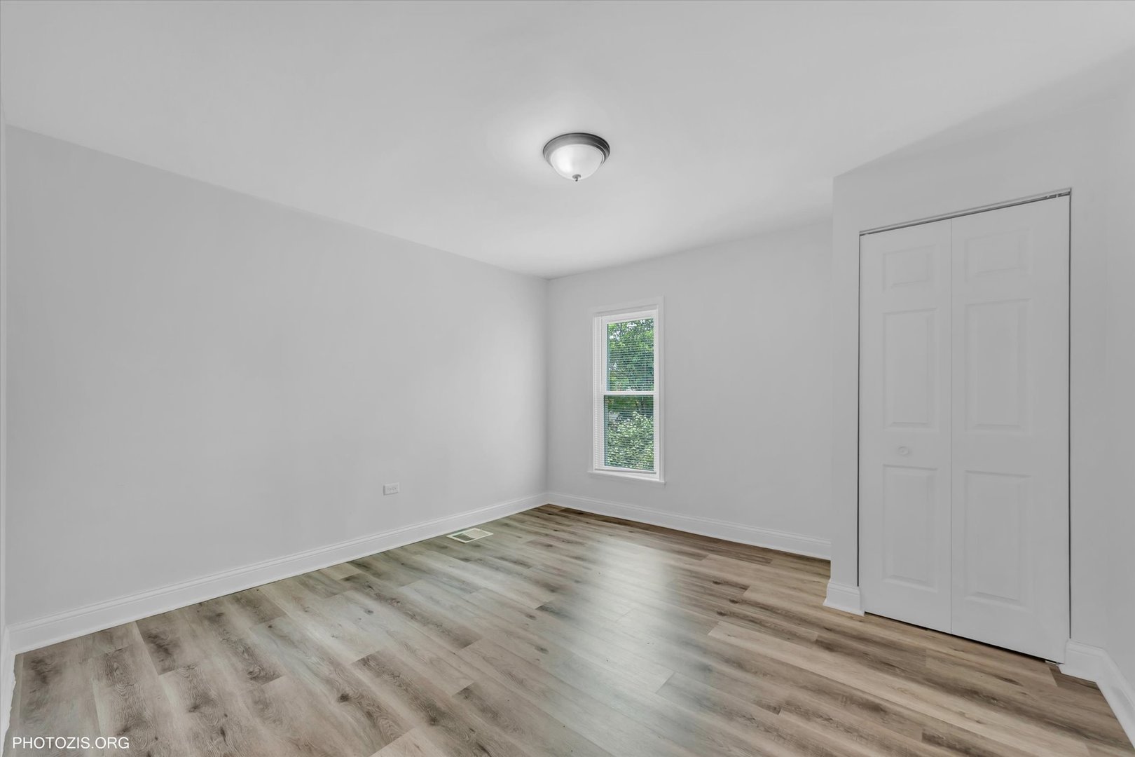 10002 South Torrence Avenue Chicago, IL 60617 - Photo 18 of 46 an empty room with wooden floor and windows