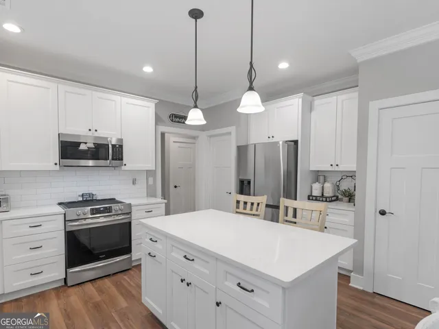 a kitchen with appliances a sink and cabinets