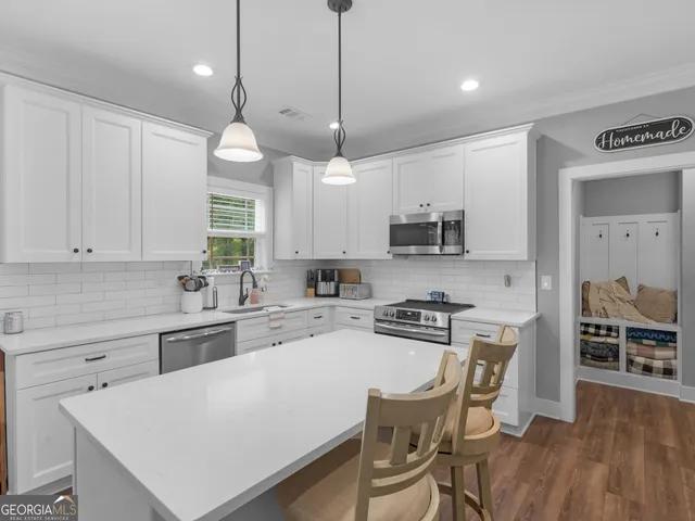 a kitchen with a stove a sink a dining table and chairs
