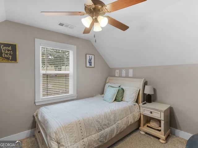 a bedroom with a bed a window and dresser