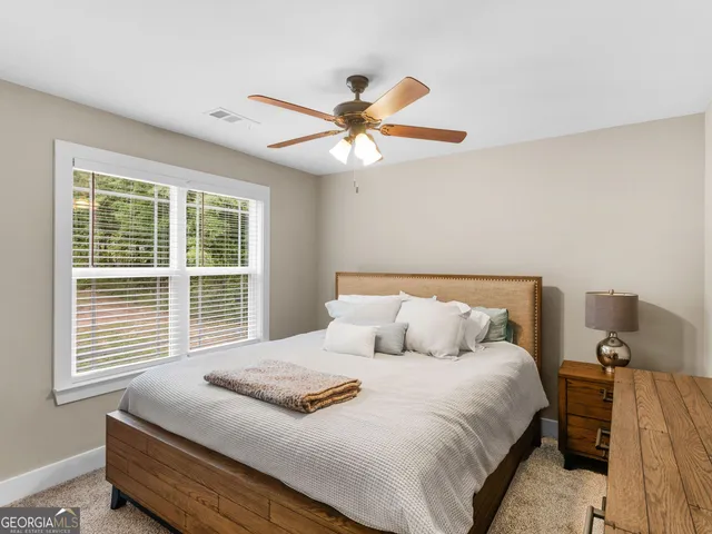 a bedroom with a bed and a flat screen tv on dresser