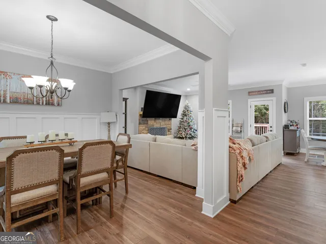 a view of a dining room with furniture a chandelier and wooden floor