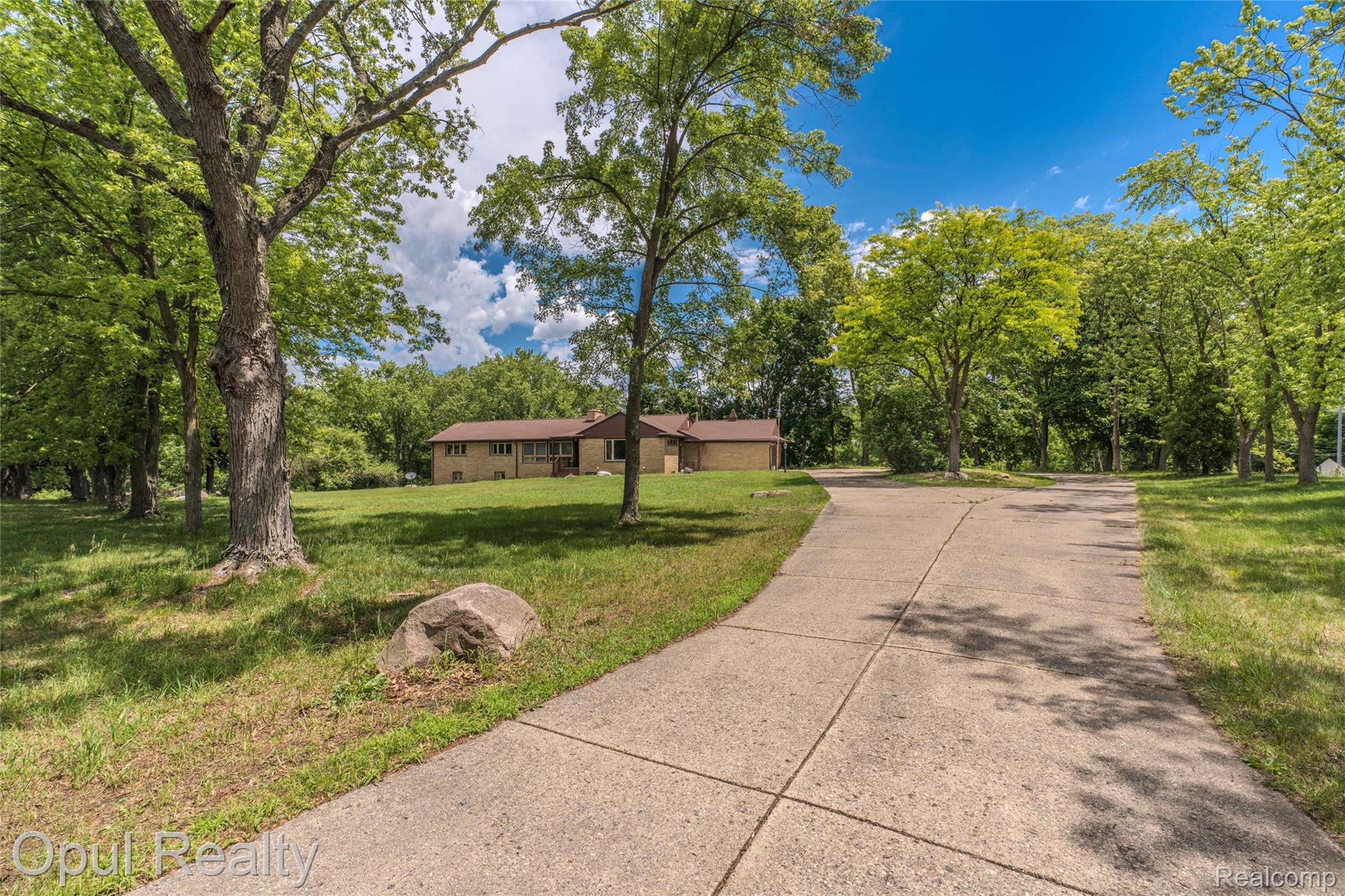 6455 Norham Road Bloomfield Hills, MI 48301 - Photo 21 of 93 Long concrete driveway leading to a residence with a brick exterior