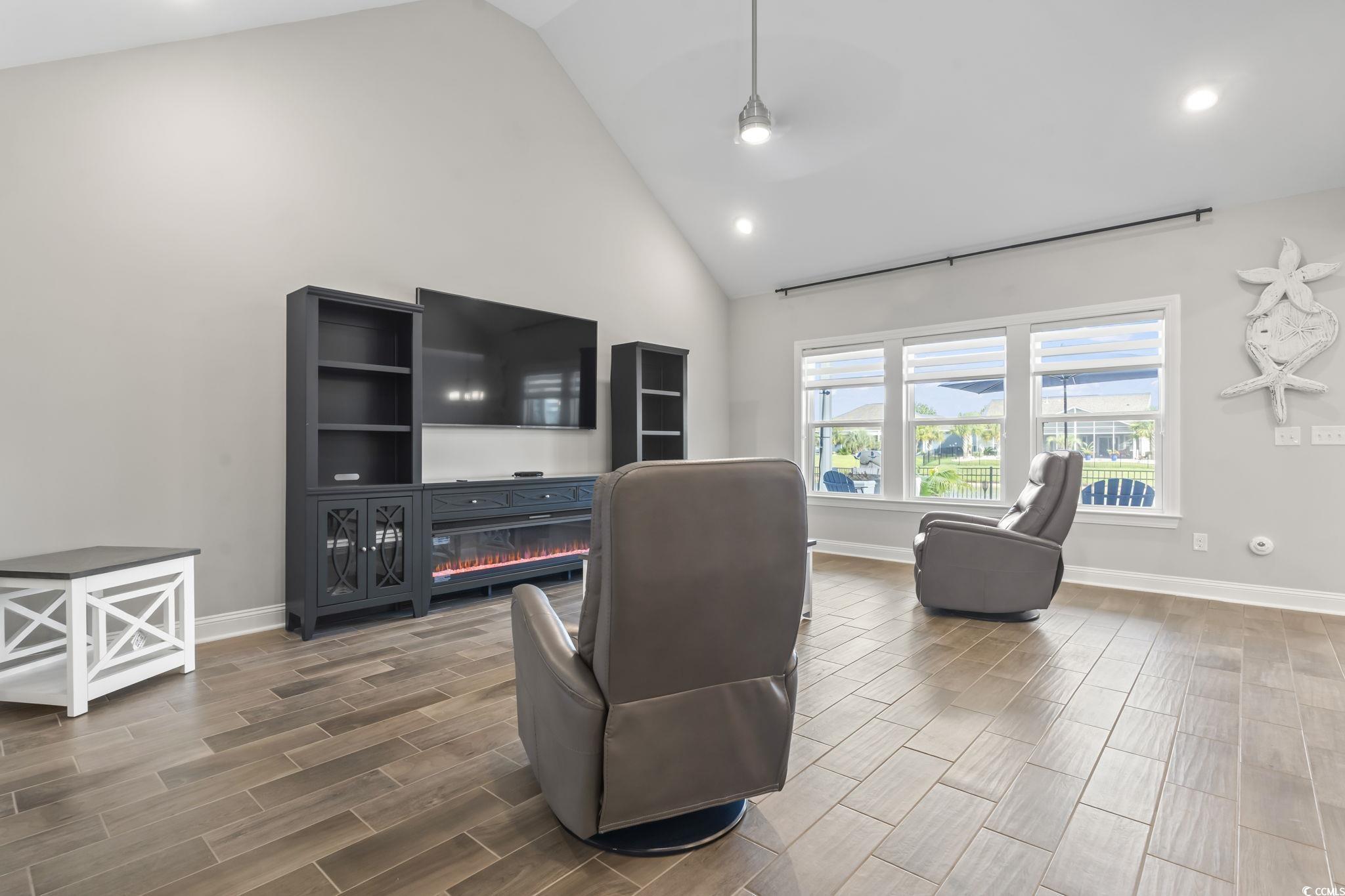 583 Hickman Street Surfside Beach, SC 29575 - Photo 19 of 40 Living room featuring high vaulted ceiling, wood tiled floors, recessed lighting, and a glass covered fireplace