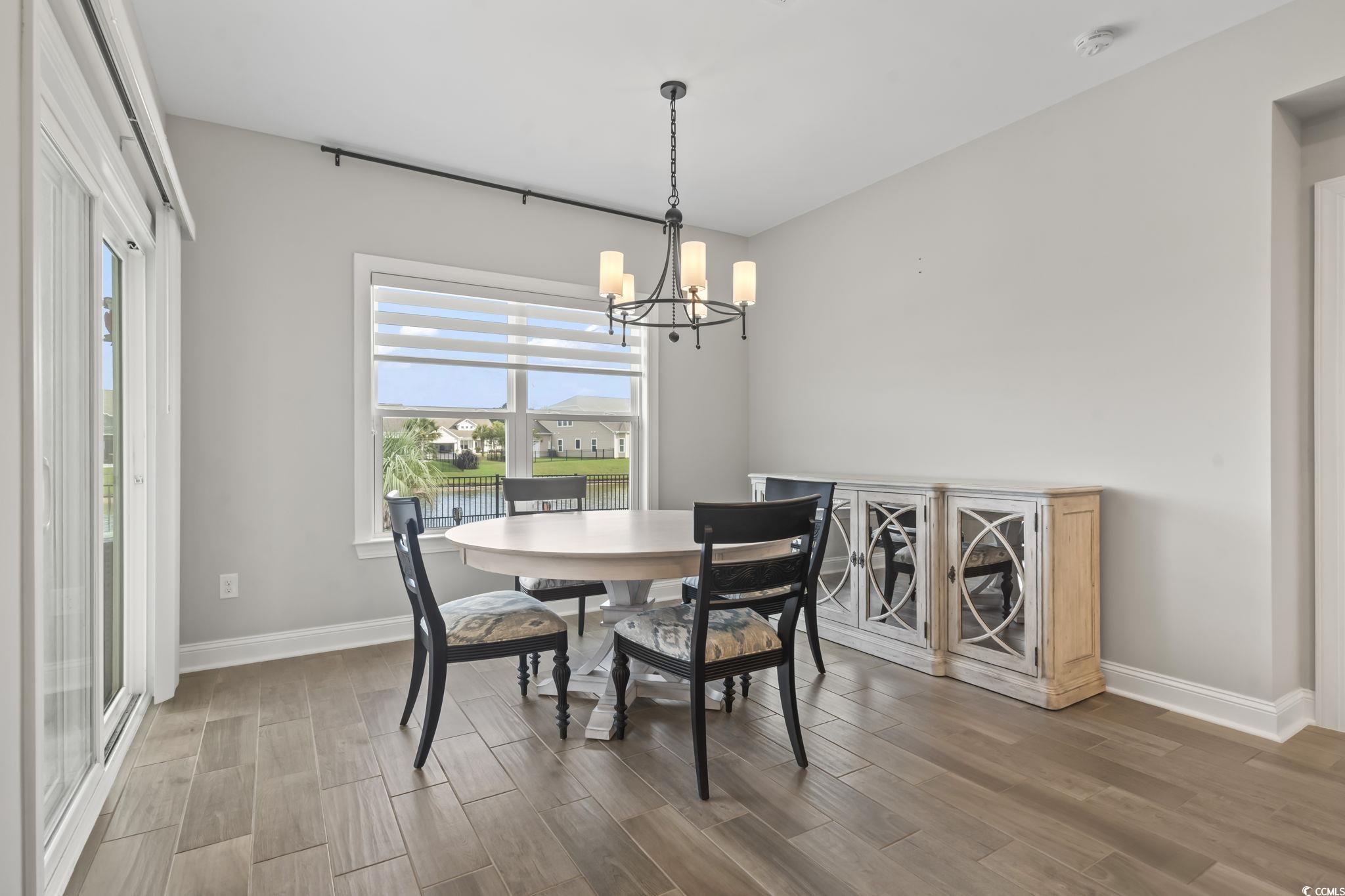 583 Hickman Street Surfside Beach, SC 29575 - Photo 23 of 40 Dining space featuring wood finished floors, a chandelier, and a water view