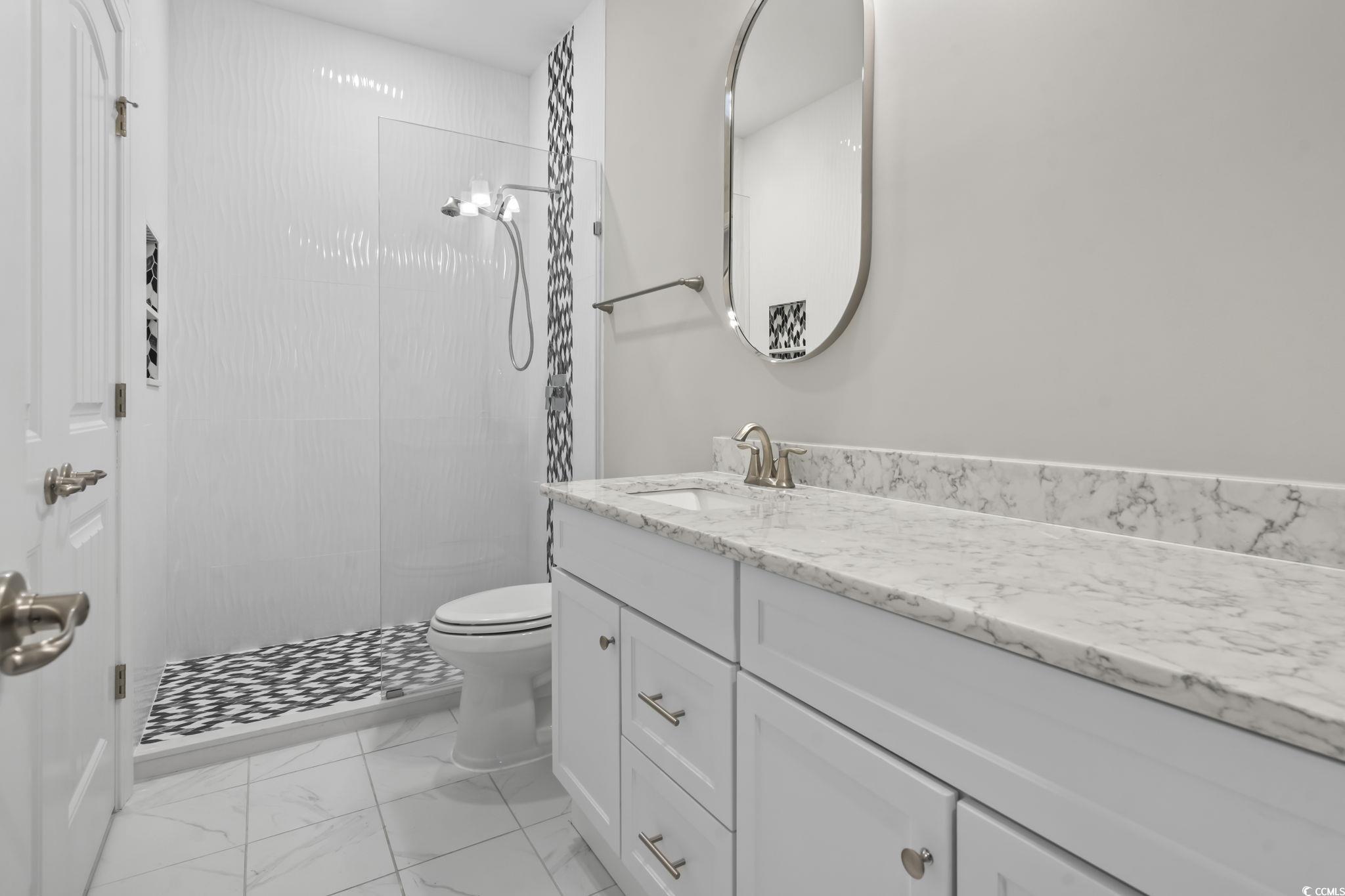 583 Hickman Street Surfside Beach, SC 29575 - Photo 29 of 40 Bathroom featuring vanity, a shower stall, and light marble finish flooring
