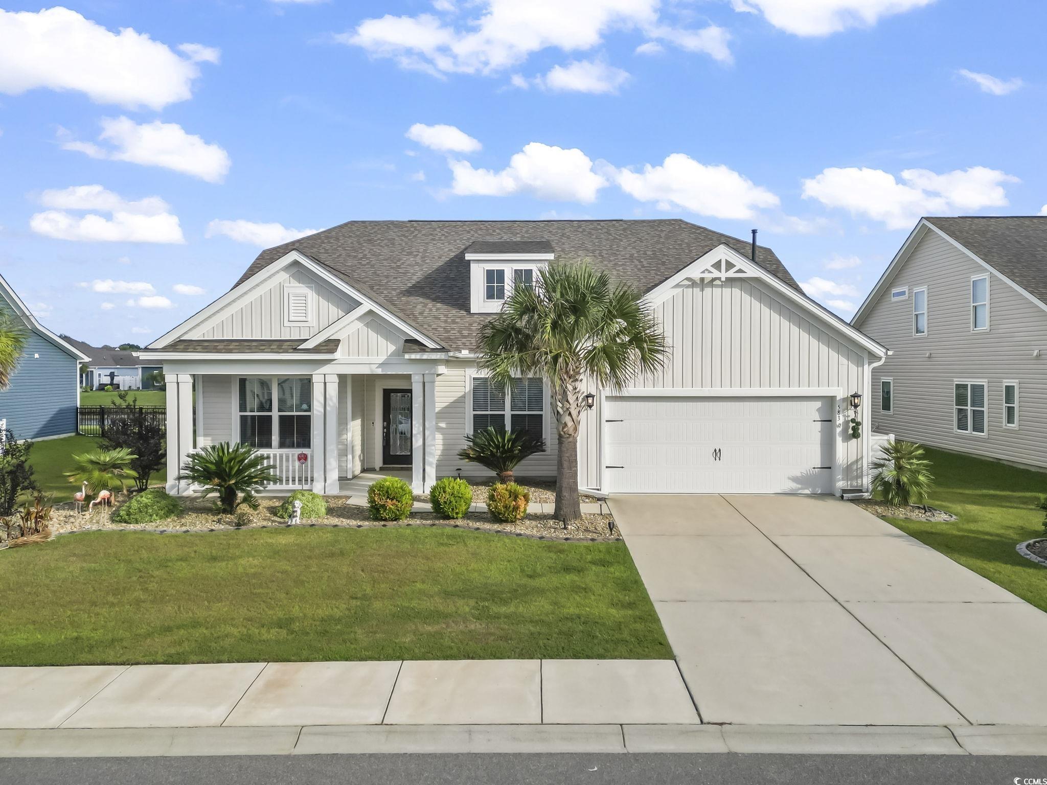 583 Hickman Street Surfside Beach, SC 29575 - Photo 3 of 40 Modern inspired farmhouse with board and batten siding, covered porch, a front lawn, and a shingled roof