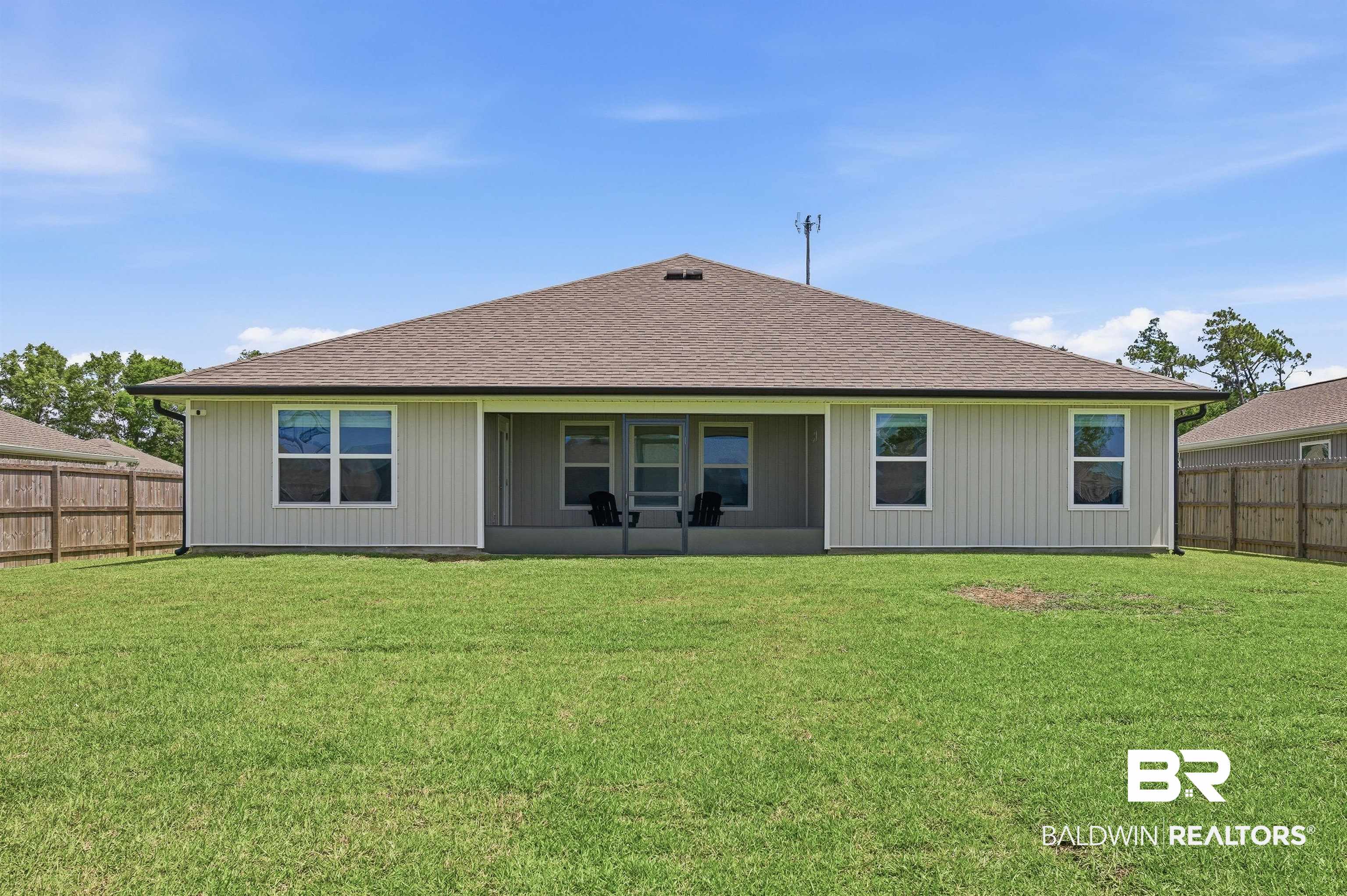 3213 Camino Real Loop Lillian, AL 36549 - Photo 7 of 61 Expansive rear yard featuring a manicured lawn, full privacy fencing, and a covered patio