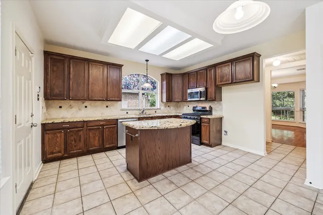 a kitchen with granite countertop a stove sink and cabinets