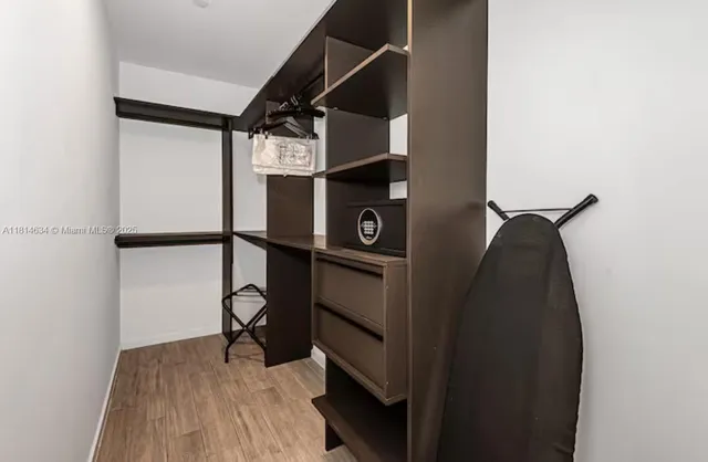 a view of walk in closet with clothes and shoes