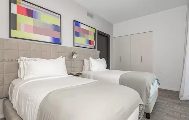 a bedroom with bed and painting on the wall